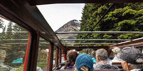 GoingToTheSun-002 Friday afternoon we piled into open-top historic red buses that date from the 1930's to drive the Going to the Sun Road from east to west where we would spend...