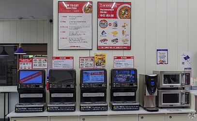 Oahu2026-010 The noodle cooking stations. The cashier gives you a disposable bowl when you pay for a noodle packet. Then the machine will scan the bar code on the packet to...