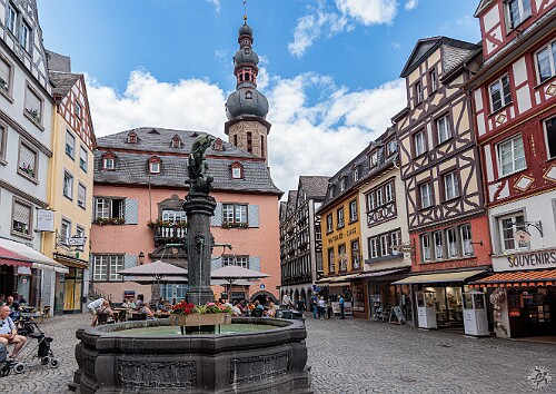 Cochem2025-036 Cochem Market Square with St. Martin Church in the background. The fountain contains a statue of St. Martin sharing his cloak with a beggar.