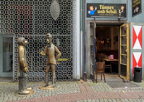 Cologne2025-030 These life-size statues celebrate the legendary Cologne puppet theatre characters Tünnes and Schäl. Tünnes was created in 1803 and is depicted as a simple,...