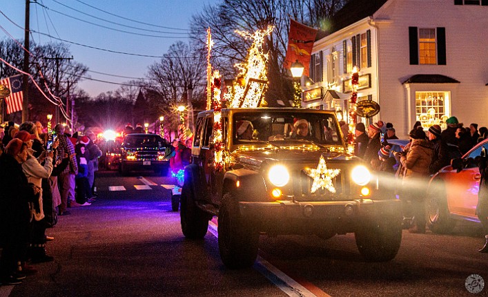 TreesInTheRigging2024-010 Several decorated vehicles parade down the street and lead the crowd in Christmas carols