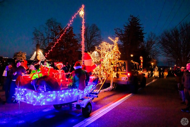 TreesInTheRigging2024-011 Several decorated vehicles parade down the street and lead the crowd in Christmas carols